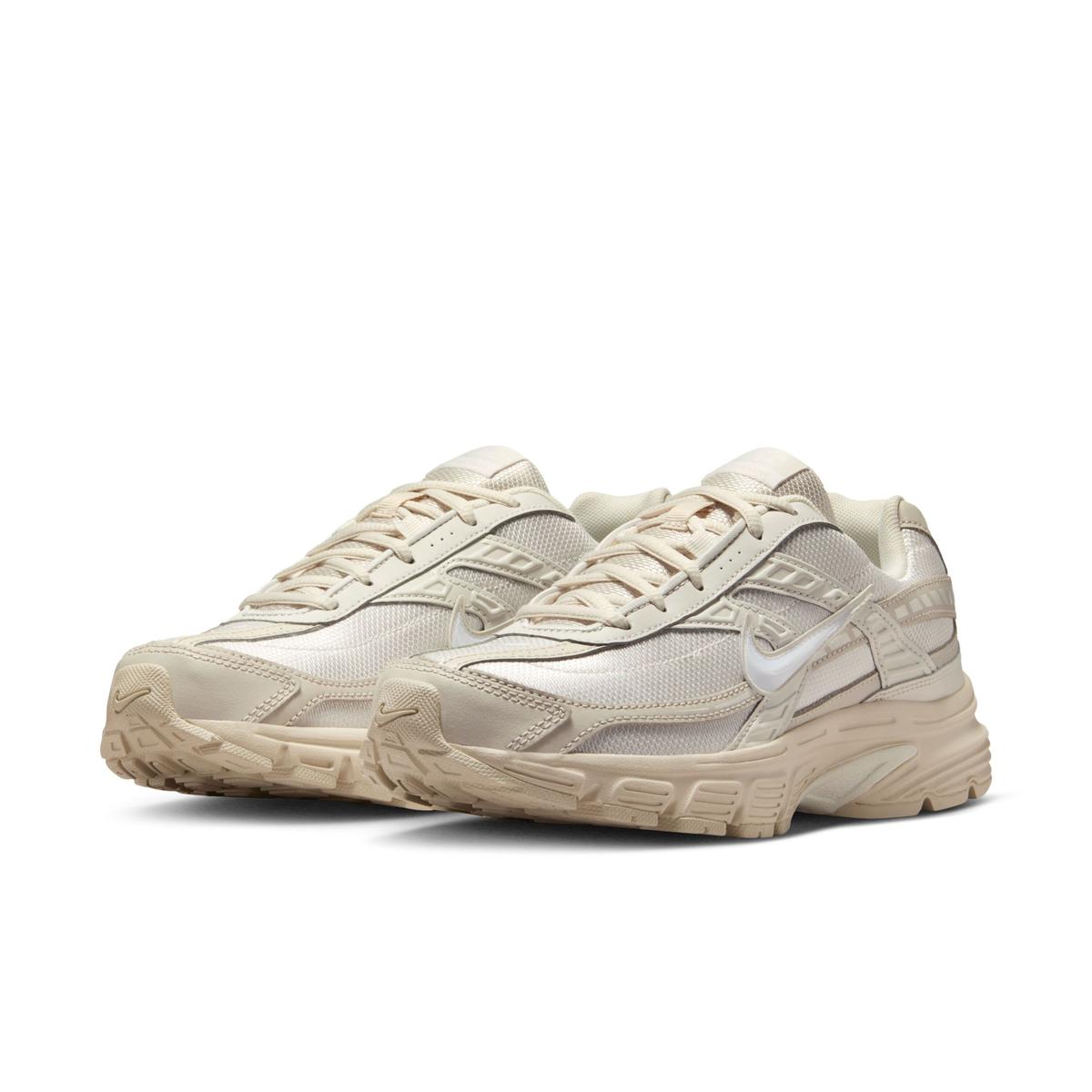 Image de la Nike Initiator Beige 394053-103, chaussure running beige en mesh avec empiècements argentés et finitions sable. (vue de 3/4)
