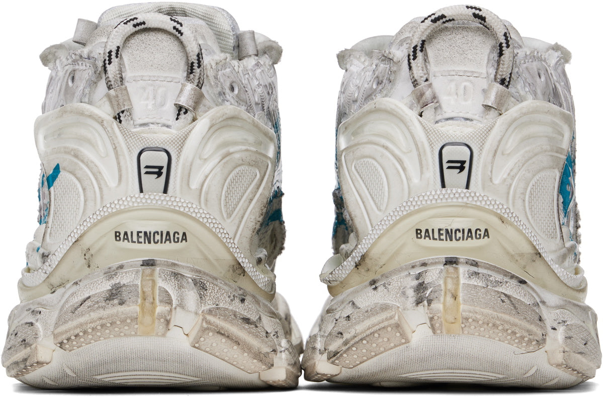 Balenciaga Runner Graffiti White Blue avec tige en mesh respirant, empiècements en cuir et matières synthétiques blanches et bleues, finitions graffiti et semelle épaisse en caoutchouc.
