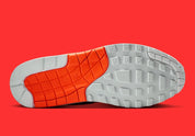 Vue sur la semelle de la Sneakers Nike Air Max 1 Patta Waves White Hyper Crimson en mesh blanc avec mudguard ondulé orange et unité Air visible.