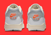 Sneakers Nike Air Max 1 Patta Waves White Hyper Crimson en mesh blanc avec mudguard ondulé orange et unité Air visible vue de derrière. 
