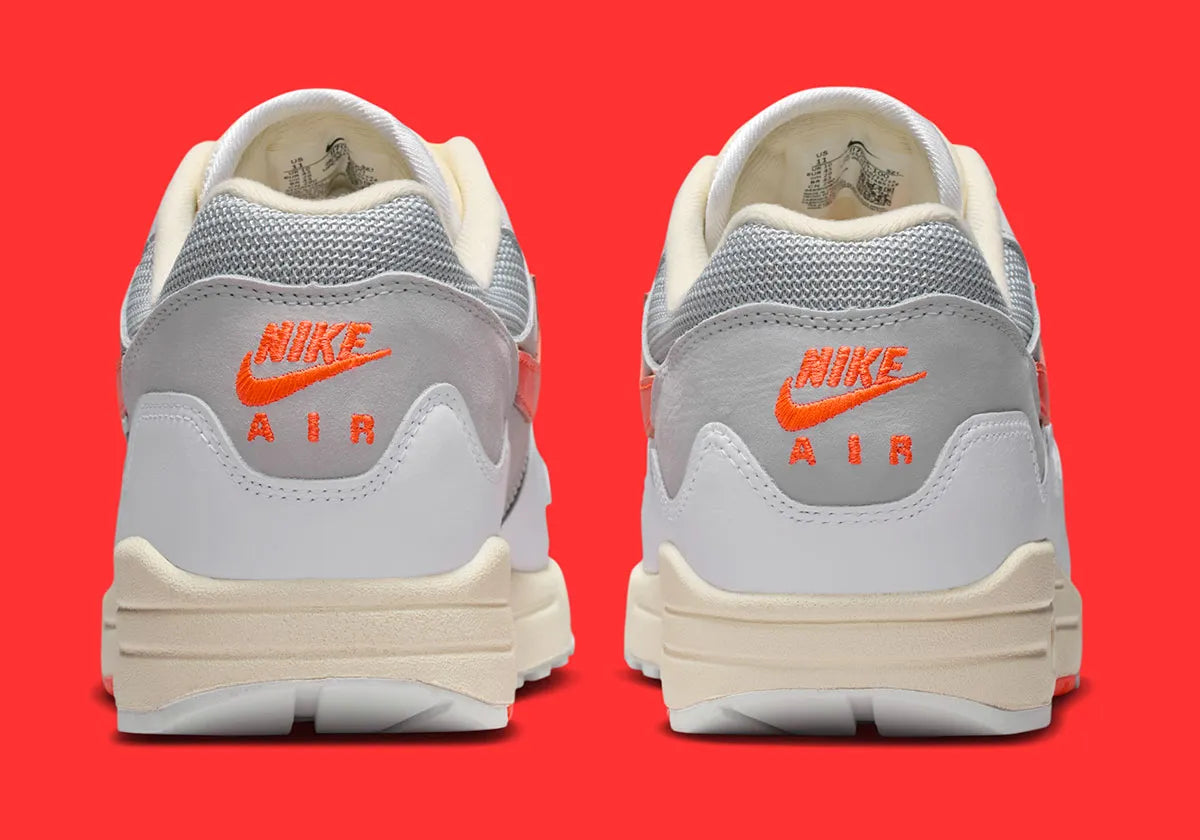 Sneakers Nike Air Max 1 Patta Waves White Hyper Crimson en mesh blanc avec mudguard ondulé orange et unité Air visible vue de derrière. 