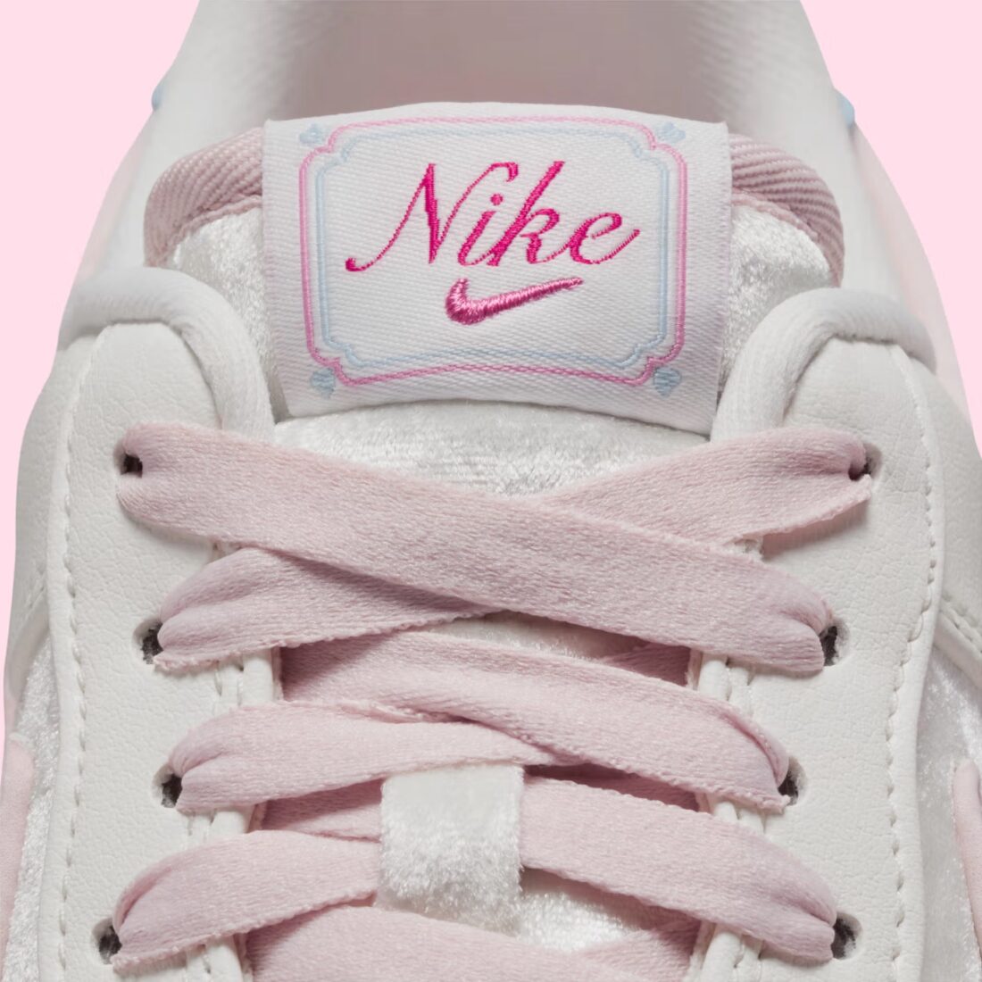 Sneakers Nike Air Force 1 Low Valentine's Day 2026 pour femme en cuir premium clair, avec détails roses et rouges, motifs exclusifs et amorti Nike Air encapsulé.Vue zoomer de face 