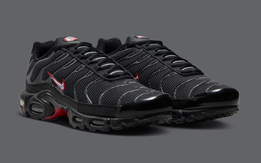 Nike Air Max Plus Black Red Metallic HF4293-001 – sneaker noire avec détails rouges et argentés, amorti Tuned Air et cage TPU iconique . Vue de profil