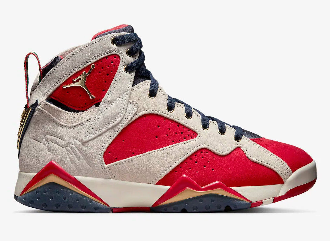 Air Jordan 7 Retro Trophy Room New Sheriff in Town DM1195-474 en suède rouge et ivoire avec languette bleu marine, détails dorés et branding Trophy Room vue de profil. 
