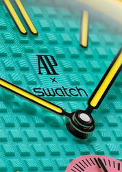 Swatch x Audemars Piguet Royal Pop Savonnette OTG Roz SSX03J100N, montre de poche mécanique en Bioceramic rose avec lunette jaune et cadran bleu-vert Tapisserie.