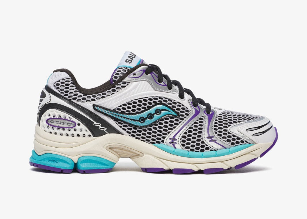 Saucony ProGrid Triumph 4 White Blue en mesh blanc avec superpositions bleues et amorti ProGrid.