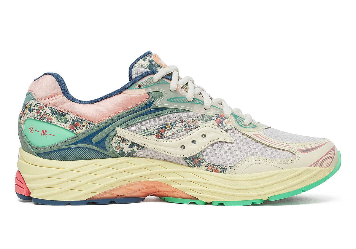 Sneaker Saucony ProGrid Omni 9 beige avec détails bleus floraux en mesh respirant et semelle amortissante ProGrid