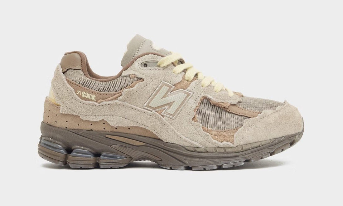 New Balance 2002R Protection Pack Brown en suède brun avec empiècements à bords bruts, semelle N-ergy et silhouette rétro-running.