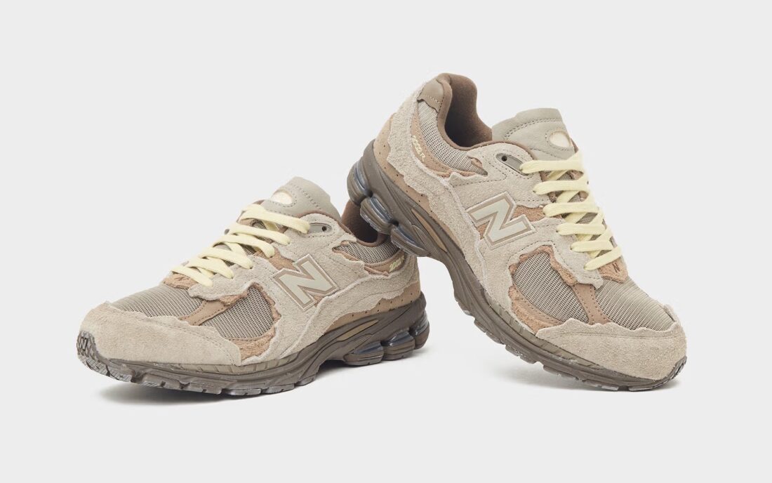 New Balance 2002R Protection Pack Brown en suède brun avec empiècements à bords bruts, semelle N-ergy et silhouette rétro-running.
