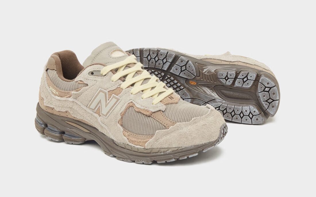 New Balance 2002R Protection Pack Brown en suède brun avec empiècements à bords bruts, semelle N-ergy et silhouette rétro-running.