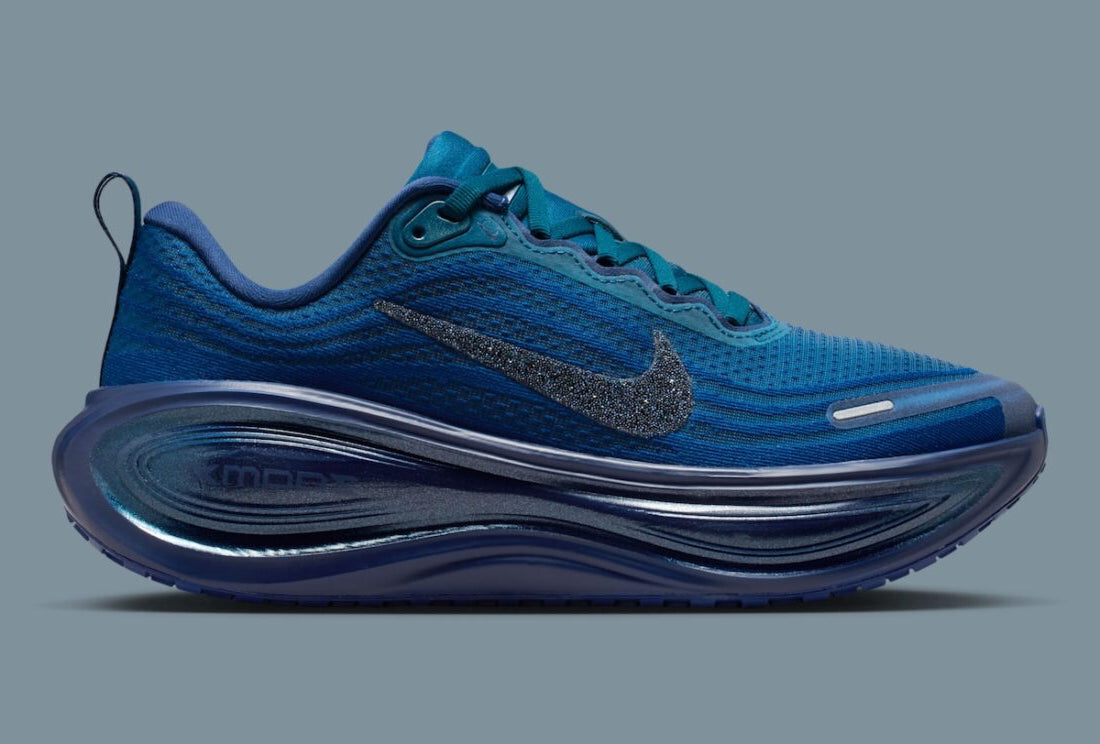 Image de la Nike Vomero Plus Swarovski Blue Force, sneaker en mesh bleu avec empiècements métallisés et cristaux Swarovski sur le Swoosh et les panneaux latéraux. Vue de profil