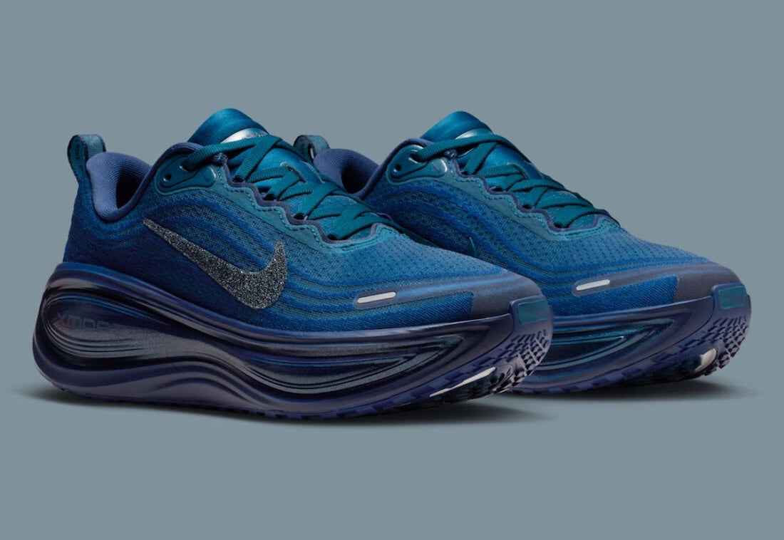 Image de la Nike Vomero Plus Swarovski Blue Force, sneaker en mesh bleu avec empiècements métallisés et cristaux Swarovski sur le Swoosh et les panneaux latéraux. Vue de 3/4 face