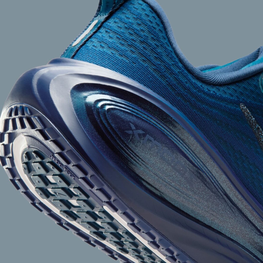 Image de la Nike Vomero Plus Swarovski Blue Force, sneaker en mesh bleu avec empiècements métallisés et cristaux Swarovski sur le Swoosh et les panneaux latéraux. Vue zoomée sur les détails arrière de la paire. 