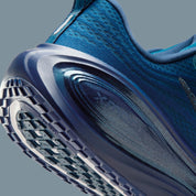 Image de la Nike Vomero Plus Swarovski Blue Force, sneaker en mesh bleu avec empiècements métallisés et cristaux Swarovski sur le Swoosh et les panneaux latéraux. Vue zoomée sur les détails arrière de la paire. 