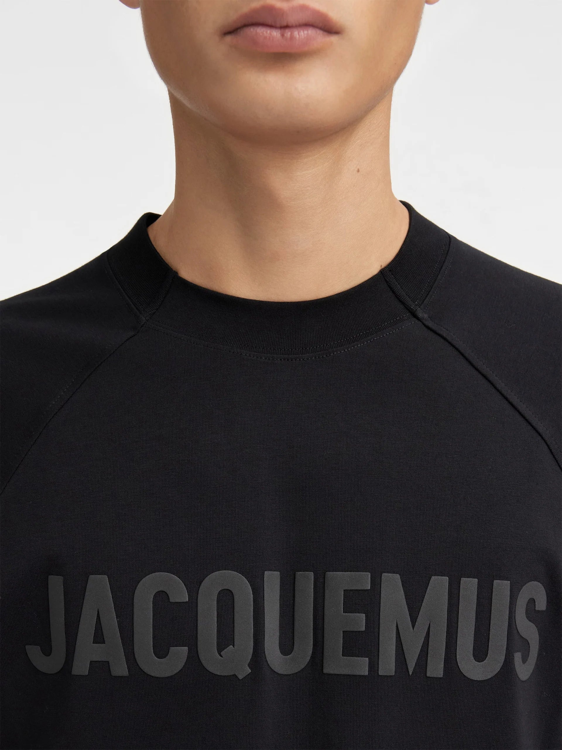 Image du tee-shirt JACQUEMUS Typo Noir Logo Noir, en coton noir premium, avec logo typographique noir ton sur ton et coupe droite contemporaine.