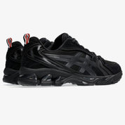 Sneakers ASICS Gel-Kayano 14 Thom Browne Black en mesh noir et cuir premium avec amorti GEL™ et détails tricolores signature vue de 3/4 arrière. 