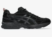 Sneakers ASICS Gel-Kayano 14 Thom Browne Black en mesh noir et cuir premium avec amorti GEL™ et détails tricolores signature vue de profil intérieur. 