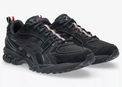 Sneakers ASICS Gel-Kayano 14 Thom Browne Black en mesh noir et cuir premium avec amorti GEL™ et détails tricolores signature vue de 3/4 face. 