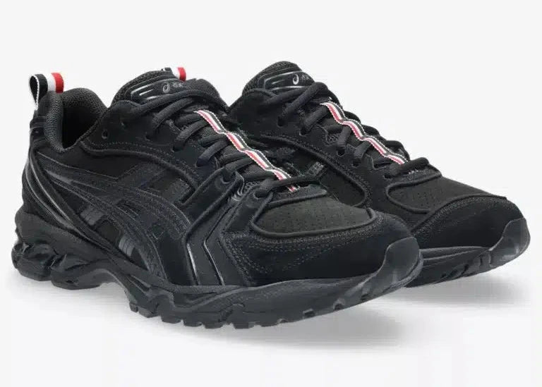 Sneakers ASICS Gel-Kayano 14 Thom Browne Black en mesh noir et cuir premium avec amorti GEL™ et détails tricolores signature vue de 3/4 face. 