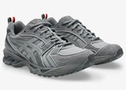 Sneakers ASICS Gel-Kayano 14 Thom Browne Grey en mesh gris et cuir premium avec technologie GEL™ et détails tricolores signature vue de 3/4 face. 