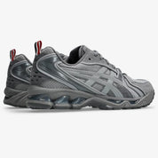 Sneakers ASICS Gel-Kayano 14 Thom Browne Grey en mesh gris et cuir premium avec technologie GEL™ et détails tricolores signature vue de 3/4 arrière. 