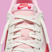 Air Jordan 1 Low Travis Scott en Sail et Tropical Pink, avec Reverse Swoosh signature et matériaux premium exclusifs.