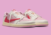 Air Jordan 1 Low Travis Scott en Sail et Tropical Pink, avec Reverse Swoosh signature et matériaux premium exclusifs.