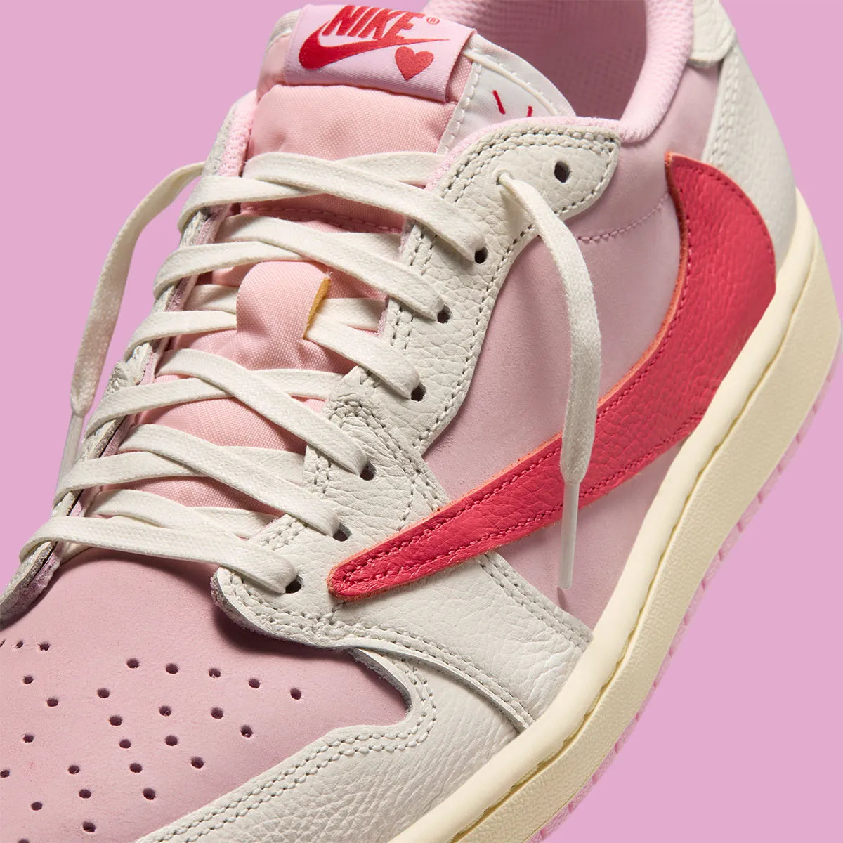 Air Jordan 1 Low Travis Scott en Sail et Tropical Pink, avec Reverse Swoosh signature et matériaux premium exclusifs.