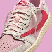 Air Jordan 1 Low Travis Scott en Sail et Tropical Pink, avec Reverse Swoosh signature et matériaux premium exclusifs.