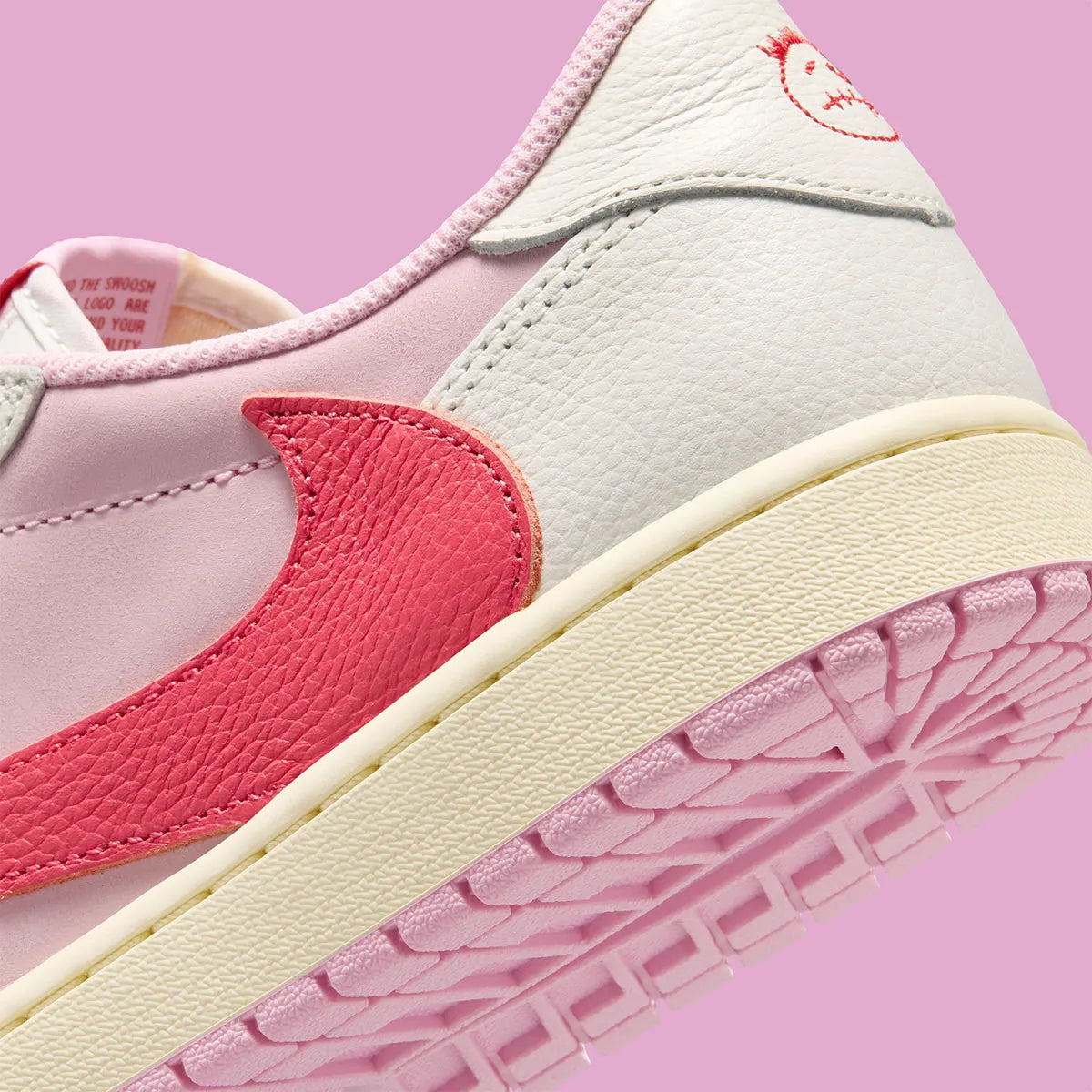 Air Jordan 1 Low Travis Scott en Sail et Tropical Pink, avec Reverse Swoosh signature et matériaux premium exclusifs.