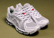 Sneaker ASICS Gel-Kayano 12.1 Up There Natsukashii Glacier Grey en mesh gris glacé avec amorti GEL et finitions premium exclusives.