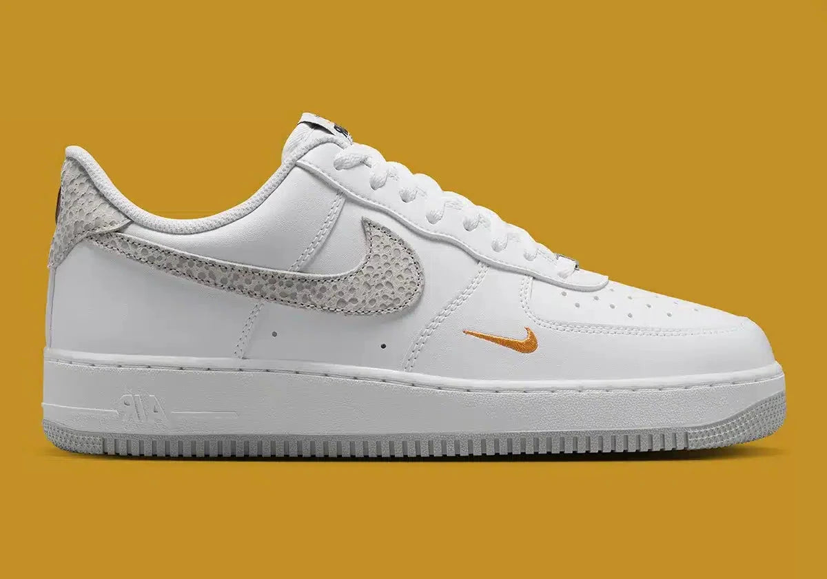 Nike Air Force 1 Low '07 White Kumquat Grey Fog, sneaker Nike blanche et grise avec détails orange Kumquat, Swoosh latéral et amorti Nike Air vue de profil. 