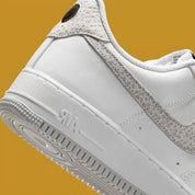 Vue zoomée sur les détails arrières de la Nike Air Force 1 Low '07 White Kumquat Grey Fog, sneaker Nike blanche et grise avec détails orange Kumquat, Swoosh latéral et amorti Nike Air.